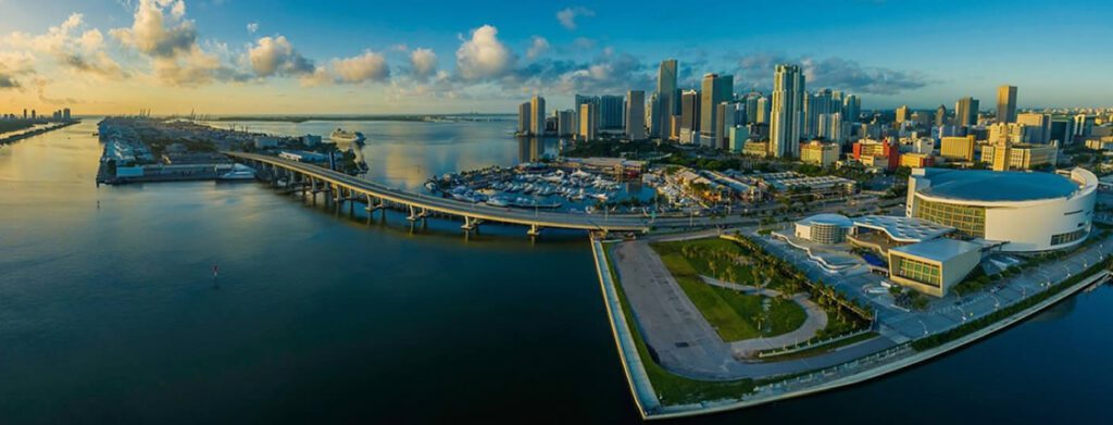 A panoramic view of a city skyline with a bridge over water.